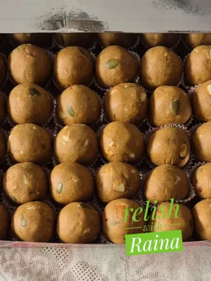 A box of Sattu Laddoos with pumpkin seeds visible on top. I often add seeds for extra crunch and nutritional benefits.