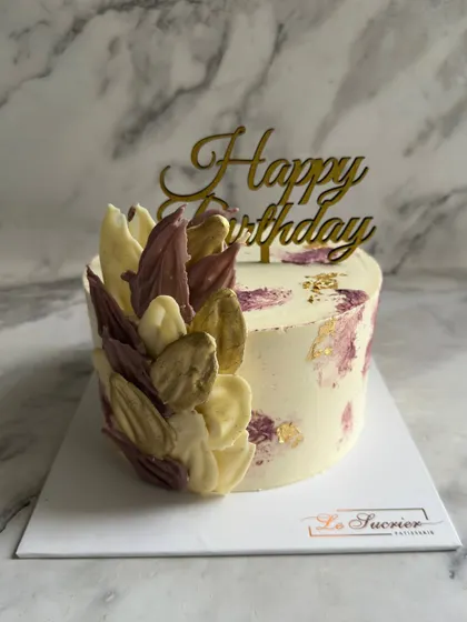 Another view of the lilac and white chocolate shard cake, showing how the light catches the different textures and the elegant "Happy Birthday" topper.
