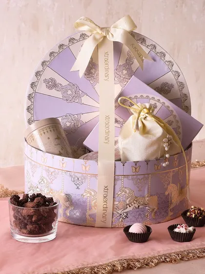 Our Amethyst Carnival hamper is a whimsical and delicious gift, with honey choco almonds, sugar-free mithai, and mini butter cookies in a beautiful carousel-themed box.