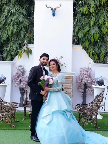 A fairytale-like pre-wedding portrait. The bride's stunning blue gown and the elegant outdoor setting create a magical, storybook feel.