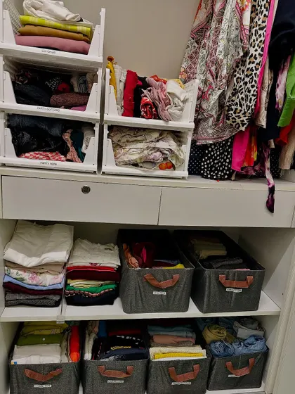 Here's a look at a finished wardrobe, where stackable bins and shelf dividers create calm out of chaos. Every category, from party tops to daily wear, has its own home.