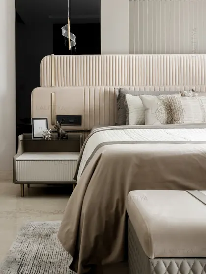 A detail shot of the son's bedroom, focusing on the clean lines and tactile materials. The fluted velvet headboard meets brushed metal accents, while the ribbed nightstand and embroidered cushions add quiet sophistication.