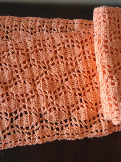 Here, the Sharad Ritu scarf is rolled up, showing the delicate and flexible fabric created by the lace pattern. It's a perfect project for beginners.