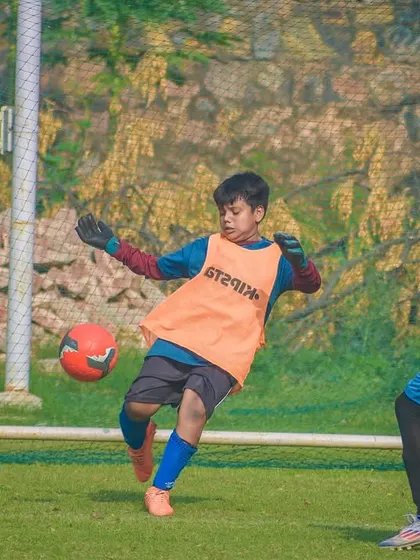 A young goalkeeper makes a crucial save, demonstrating the importance of every position on the field.