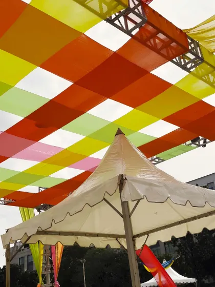 A close-up of the colorful overhead decor for a Dandiya night. I use a combination of trussing and vibrant fabric drapes to create a festive canopy, transforming an open space and adding to the celebratory atmosphere.