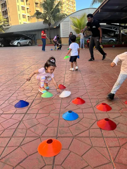 A young girl carefully places a cone during a drill. Even simple tasks like this help build focus and motor skills in our toddler programs.