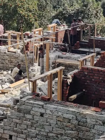 An aerial view of the guesthouse site during the early stages of construction. The layout of the separate structures is visible, scattered across the terrain to create a small, village-like cluster.