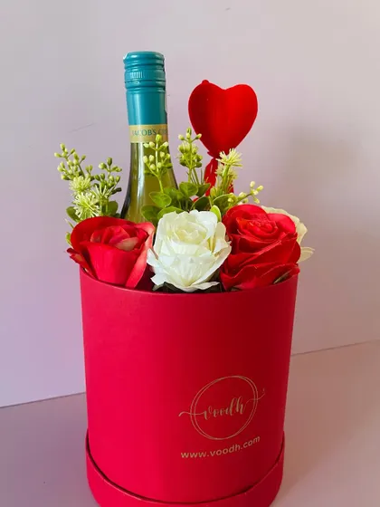 Say "cheers" to love with this romantic wine hamper. A bottle of wine is beautifully arranged with red and white roses in a round box.