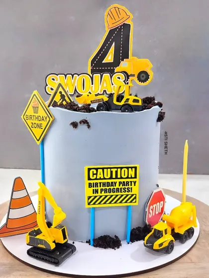 A construction zone birthday cake for a little builder. This White Chocolate Mousse cake is complete with toy trucks, signs, and edible dirt.