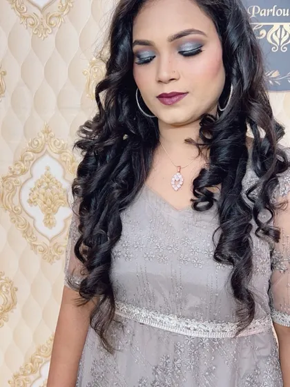 A glamorous look for an evening event, featuring silver smokey eyes and a deep plum lip colour. The hair is styled in voluminous curls.