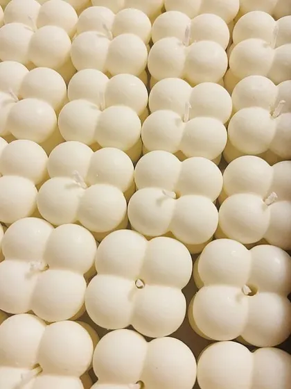 A bulk order of white bubble candles, neatly arranged in a box. Their minimalist look makes them suitable for any occasion.