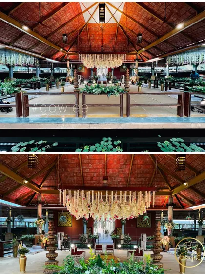 The stunning interior of a wedding hall with a rustic roof, decorated with a large central floral chandelier.