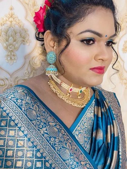 This look is perfect for a festival or traditional event, with a beautiful blue saree and matching turquoise jhumkas and eye makeup.