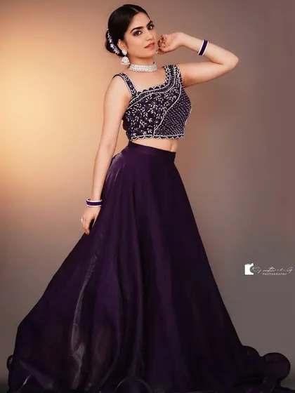 A full-length view of the deep purple lehenga. The flowing organza skirt and the heavily detailed blouse make it a perfect outfit for a sangeet or cocktail party.