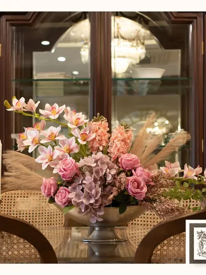 This timeless artificial arrangement, featuring a mix of pink roses, orchids, and hydrangeas, brings warmth and charm to this dining setting. It's a perfect centerpiece for both classic and contemporary interiors.