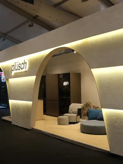 This angle highlights the inviting curve of the main arch and the way it frames the interior display. The design is subtle yet striking, a physical manifestation of the Plüsch brand's ethos.