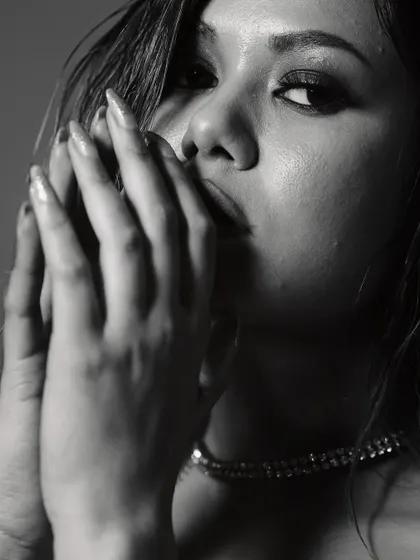 A soft and mysterious portrait. The model's hands frame her face, creating a sense of intimacy, while the black and white tones and soft focus add a timeless, film-noir feel.