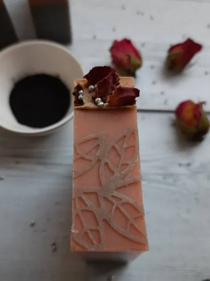 Detail is so important to me. This close-up of my Charcoal Rose soap shows the delicate leaf pattern I stamp by hand, topped with real dried rose petals for a touch of luxury.