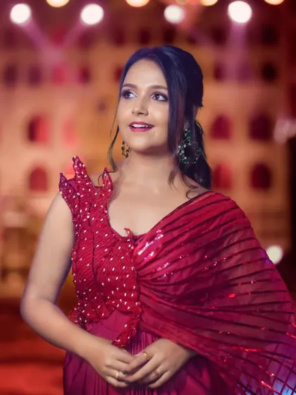 A portrait of actress Nisha Milana at the Zee Kutumba Awards. The colorful background and stage lighting make for a vibrant and celebratory shot.
