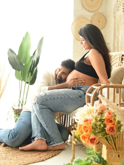 A tender pose where the father-to-be listens to the baby bump. Set in our warm, naturally-styled boho corner, this image is filled with love and anticipation.
