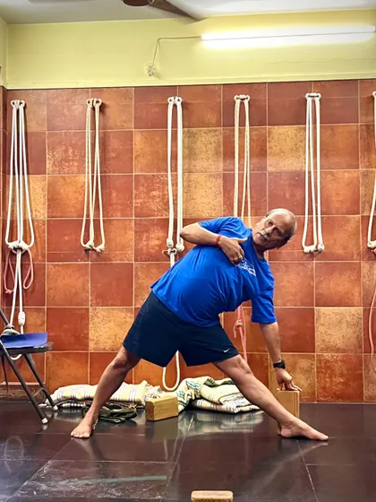 A demonstration of Utthita Trikonasana (Triangle Pose) using a block for hand support. This ensures the chest remains open and the spine stays aligned, which is the true purpose of the asana.