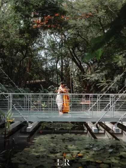 A couple sharing a quiet moment on a bridge in a lush, green setting. This is perfect for intimate weddings where the focus is on the couple's connection.