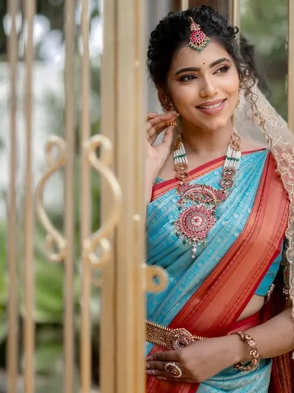 A beautiful shot from our collaboration, featuring a unique turquoise and red saree. The makeup is kept soft and elegant with a delicate veil.