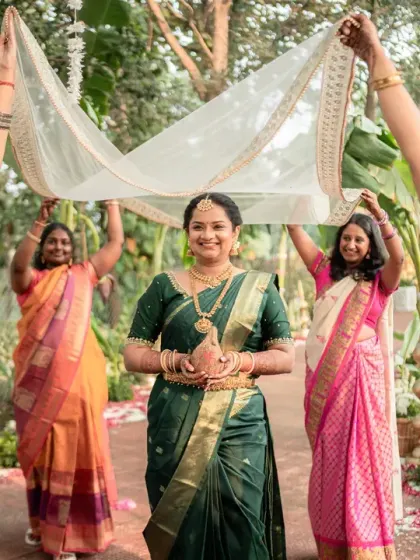 A wider shot of the bride's entrance, showing the vibrant sarees of the women accompanying her. This photo captures the colour, community, and joy of a South Indian wedding.
