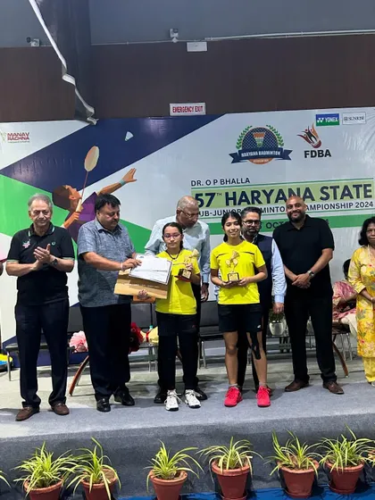 Nandini and her partner receiving their gold medals on stage at the 57th Haryana State Sub-Junior Badminton Championship.