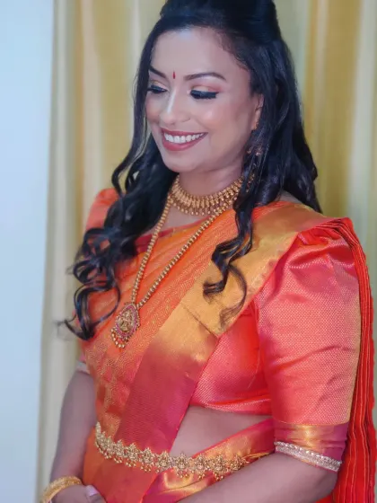 The soft curls and half-up hairstyle perfectly frame her face, creating a modern yet traditional look.