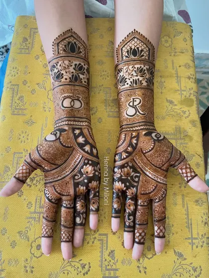 An elegant engagement mehendi featuring the couple's initials 'SR' and intertwined wedding rings. It's a perfect way to celebrate the start of a new journey together.
