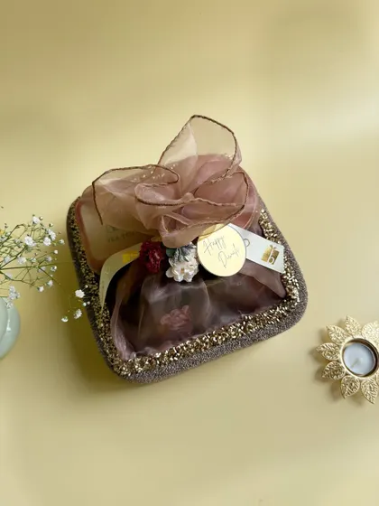 This elegant Diwali hamper is perfect for corporate gifting. Wrapped in delicate organza with a gold "Happy Diwali" tag, it contains a curated assortment of items designed to impress valued clients and employees.