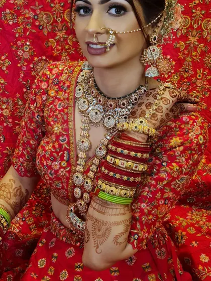 My "Sohni" bride, looking absolutely lovely. Her makeup is flawless, and her intricate red lehenga and jewelry complete the perfect bridal picture.