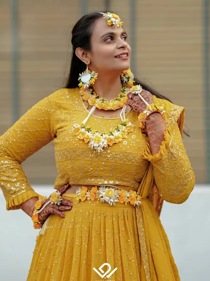 A stunning portrait of a bride dressed for her Haldi ceremony, adorned with beautiful floral jewelry.