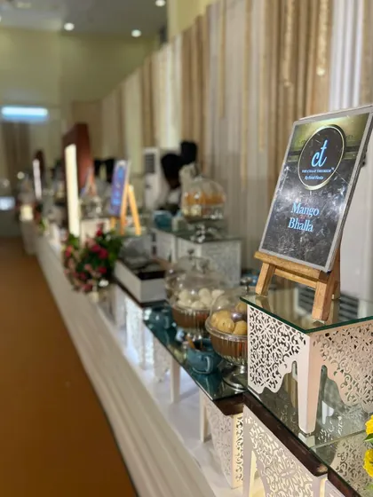 A view of my elegant chaat counter setup at a festive event. The station features a variety of items, including a sign for "Mango Bhalla," a unique seasonal twist on a classic.