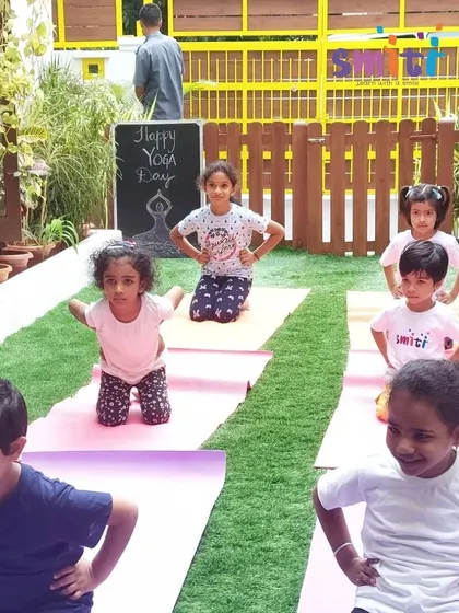 Children smile as they practice a pose on their yoga mats. Our yoga sessions are filled with positivity and encouragement.