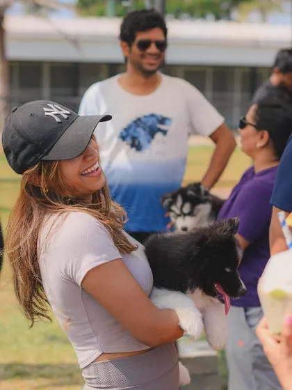 A candid shot of a happy guest holding a fluffy puppy during one of our events.
