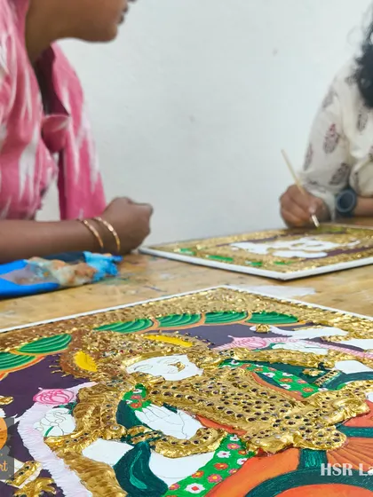 A candid shot of students working together on their Tanjore pieces, sharing a moment of creative focus in the studio.