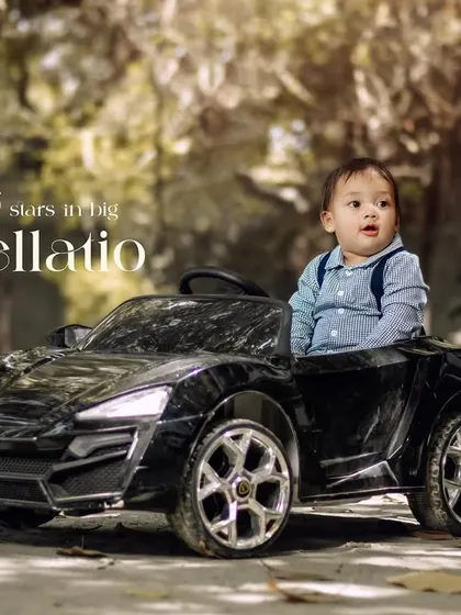 Little stars in big constellations. A toddler in suspenders takes a ride in his toy car on a wooded path.