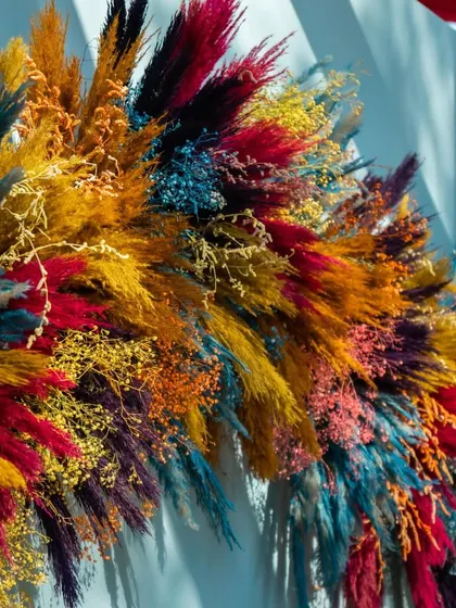 A close-up of the stunning floral arrangement made from multi-colored dried pampas grass, which served as a key decorative element for the carnival theme.