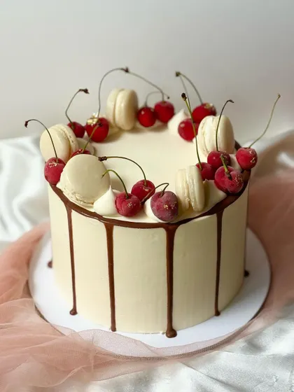 A duplicate image of the irresistible cherry and macaron drip cake, showcasing the glossy chocolate drip and fresh toppings.
