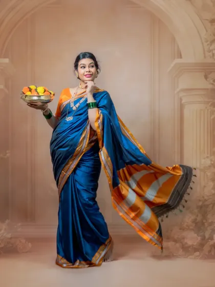 The vibrant blue and orange saree truly stands out in this portrait. The flowing pallu adds movement and elegance, capturing the radiant glow of the mom-to-be.