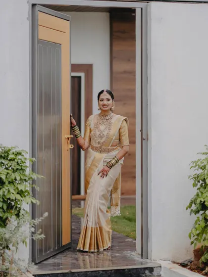 A welcoming pose, as the bride stands at a doorway, her smile inviting and warm.