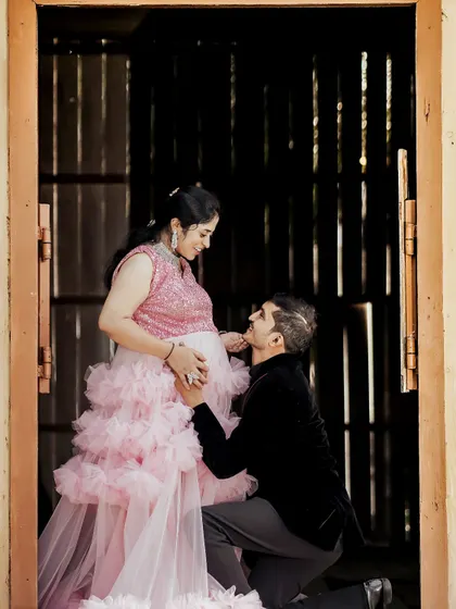 A tender moment captured during a maternity photoshoot. The couple chose this lovely pink ruffle gown, and we also provide blazers for the partner to create a coordinated look.