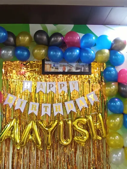 A simple birthday backdrop with a gold shimmer curtain and a colorful balloon frame. This is an easy and effective way to create a photo corner at home.