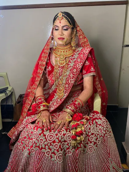 A full portrait of my stunning bride in a classic red lehenga. The makeup is centered around bold red lips and defined eyes, paired with heavy gold jewellery for a complete, traditional bridal look.