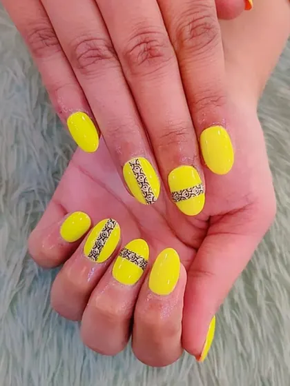 A vibrant yellow set featuring a detailed black lace pattern. This demonstrates the precision work and fine-line detail that we teach in our hand-painting modules.