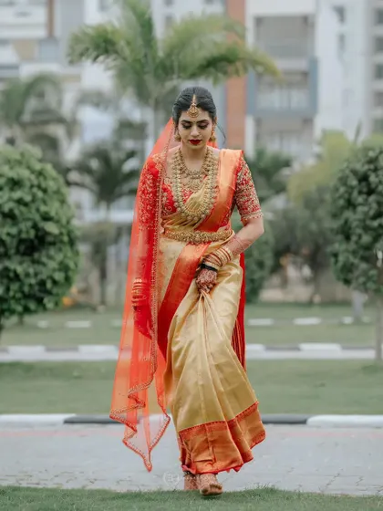 The bride walking in the garden, her elegant saree and mehendi creating a timeless look.