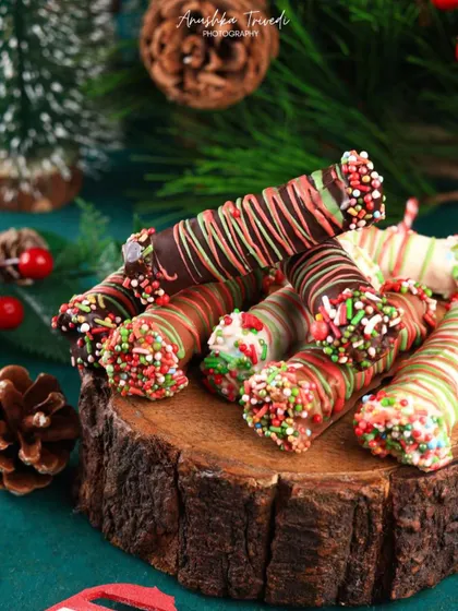 A tight shot of the Christmas chocolate rolls, emphasizing the colorful sprinkles and drizzled chocolate details.