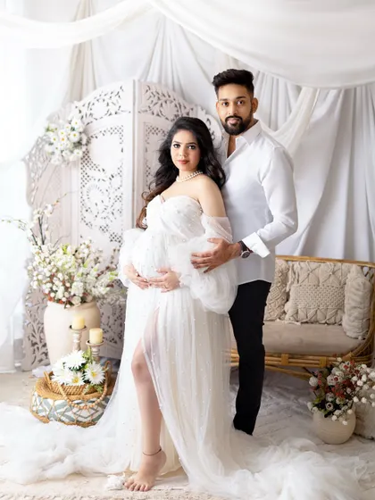 A glamorous mom-to-be celebrating her journey. I provide a collection of beautiful maternity gowns, like this elegant white dress, to make you feel absolutely radiant. This portrait was taken in my studio against a soft, dreamy backdrop.